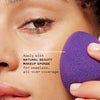 Model applying concealer tint with natural beauty makeup sponge